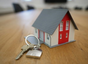 white and red wooden house miniature on brown table